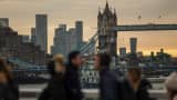 Työmatkalaiset ylittävät London Bridgen, josta on näköala Tower Bridgelle ja Canary Wharfin alueelle Lontoossa, Isossa-Britanniassa, tiistaina 18.11.2025. 